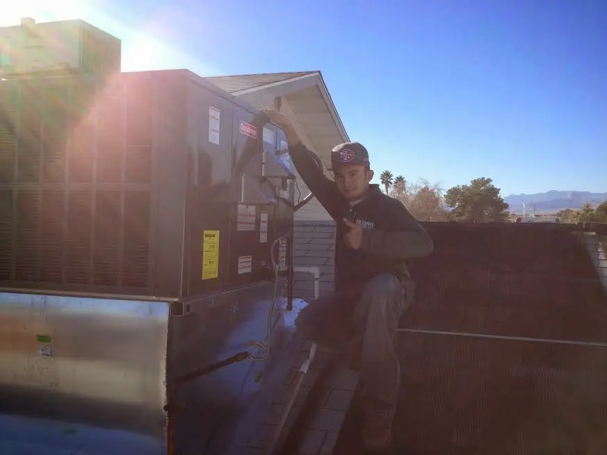 HVAC technician performing AC Tune-Up on a rooftop unit in Fortuna Foothills